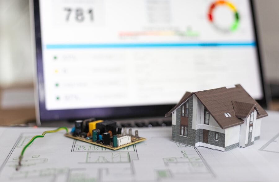 A real estate model and a computer are on the table.
