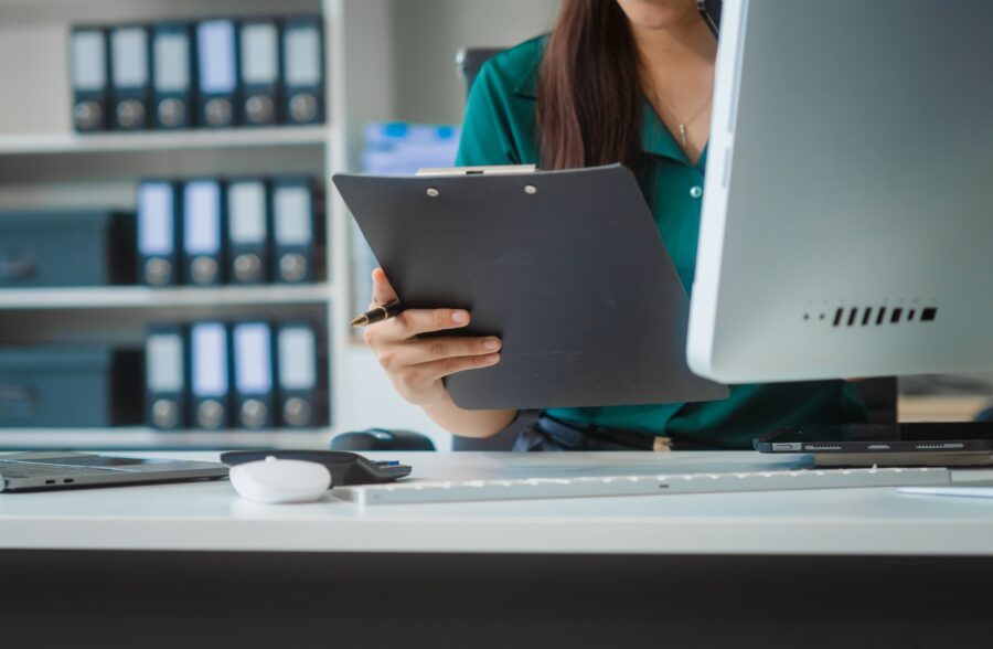 Asian businesswoman in formal attire works on laptop, on corporate law and marketing strategy.
