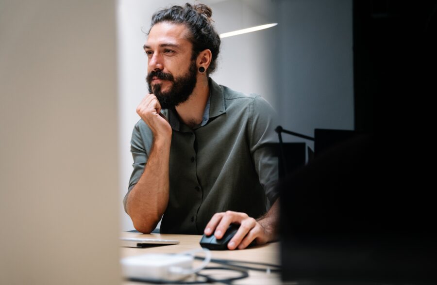 Concentrated young business man employee worker analyzing online sales statistics data on computer